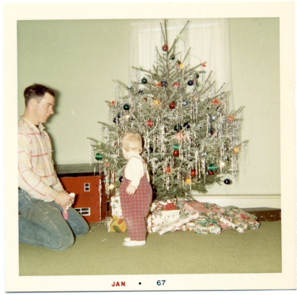 old picture of father with baby near Christmas tree